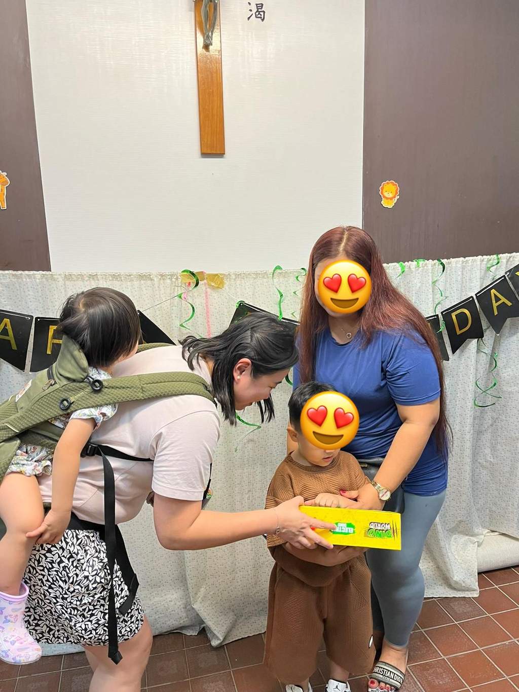 Adults help a child open a bright boxed gift.