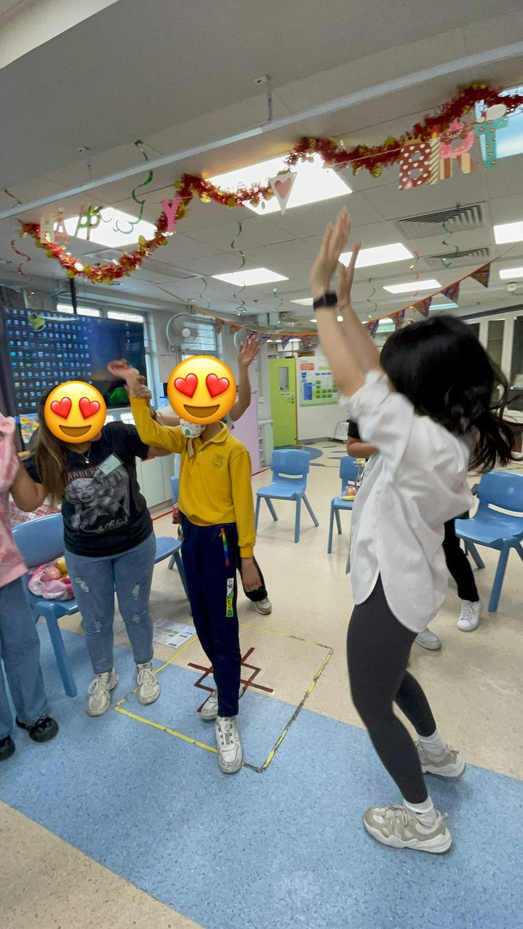 An adult raises an object while participants watch nearby.