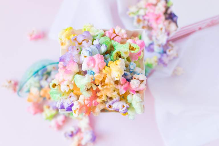 A spoon lifts a scoop of colourful sprinkled cake.