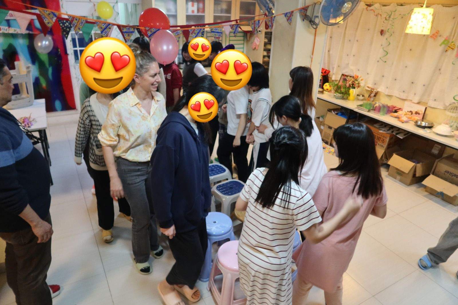 A group stands near a long table filled with party food.