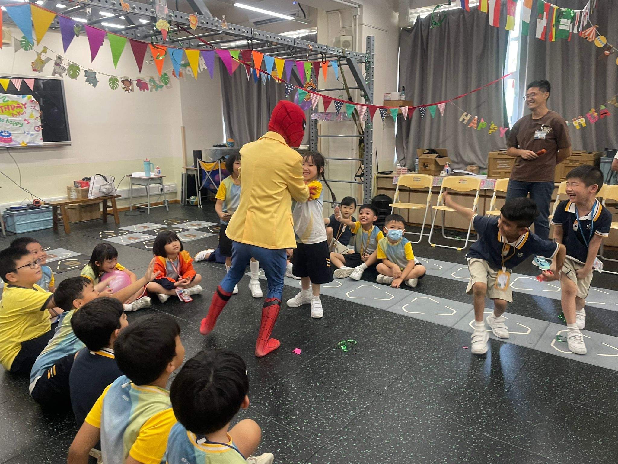 Children sit around a costumed performer leading a floor activity.
