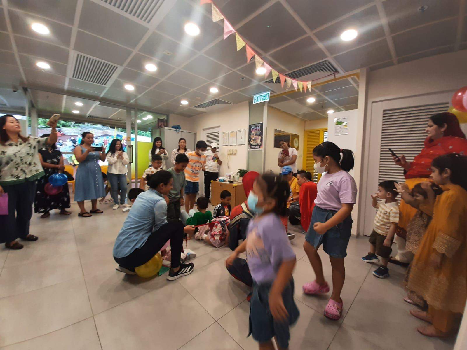 Children cross the open floor during an active group game.