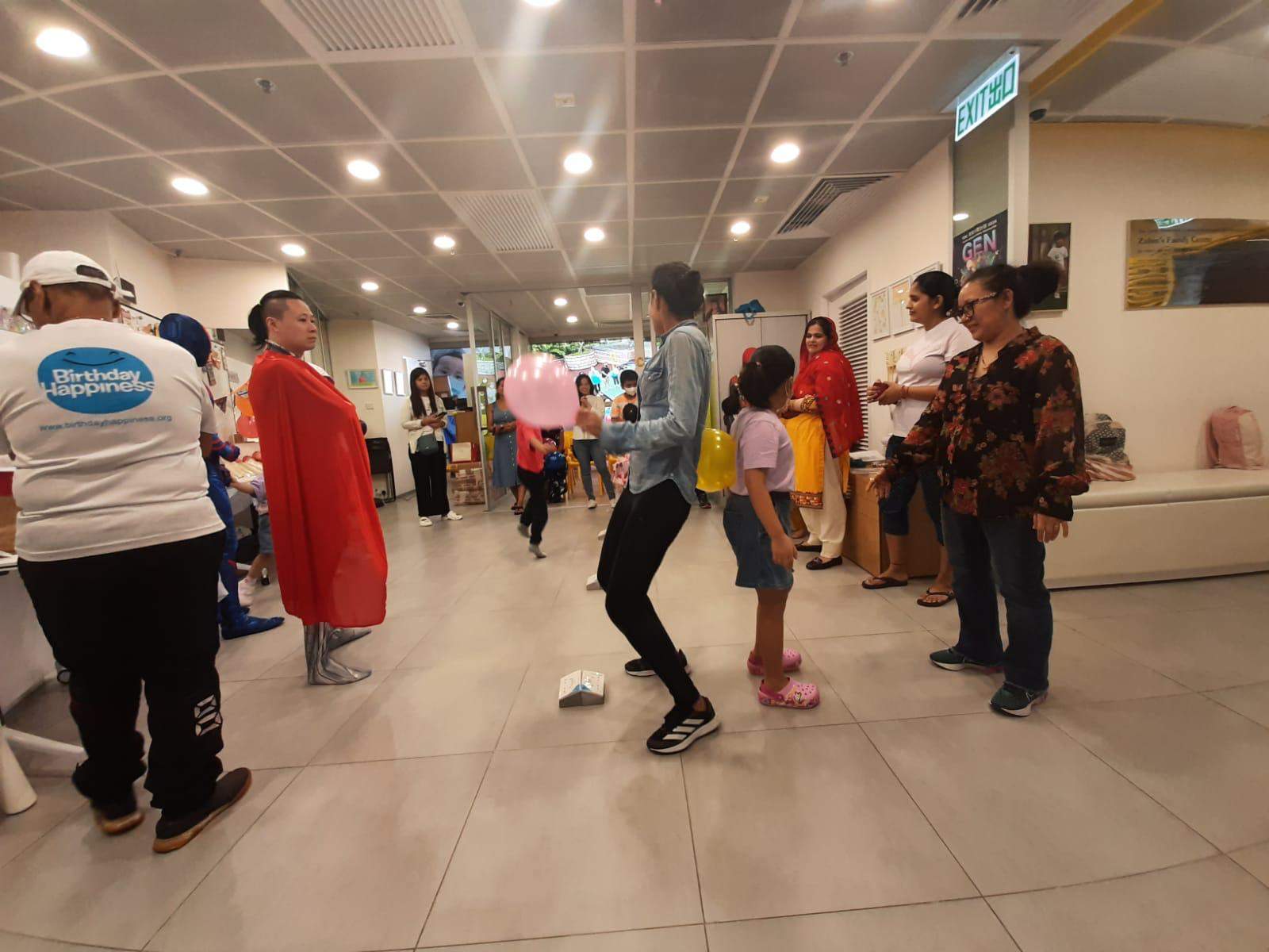 Adults and children mingle during an activity in the decorated room.