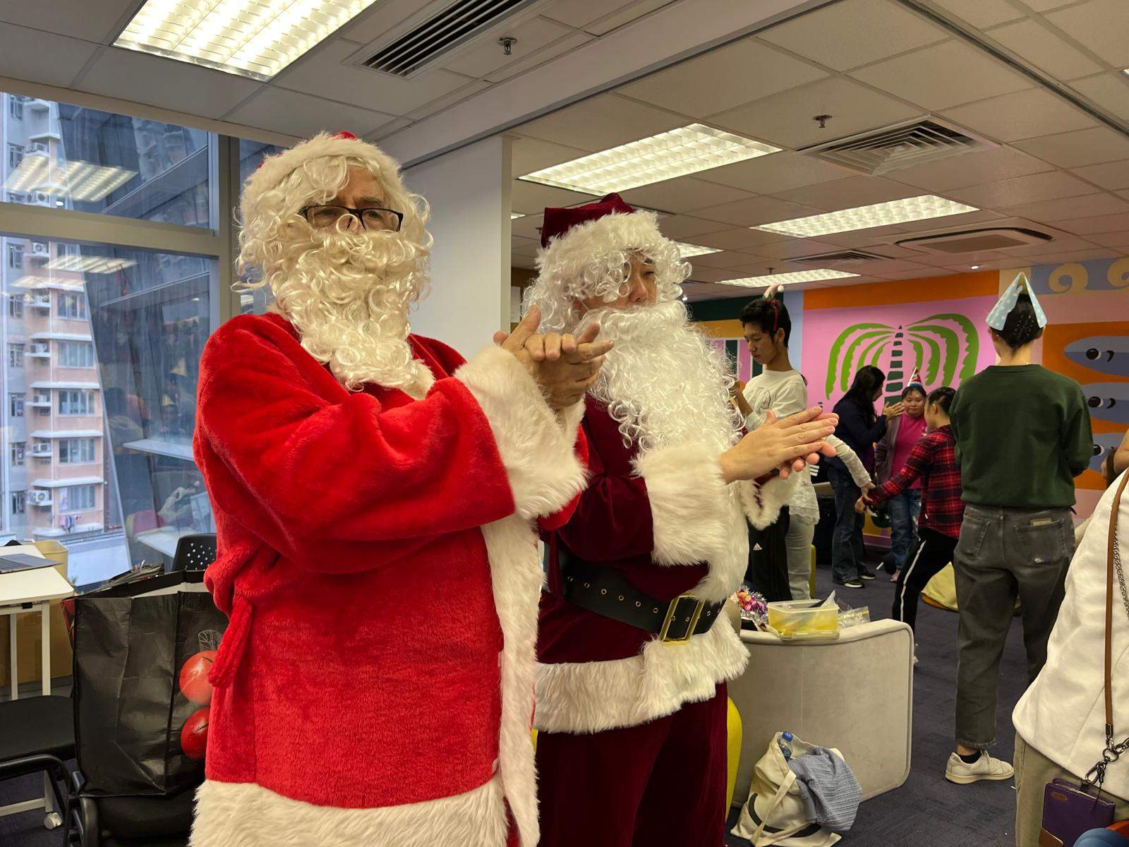 Two costumed adults stand together near a window.