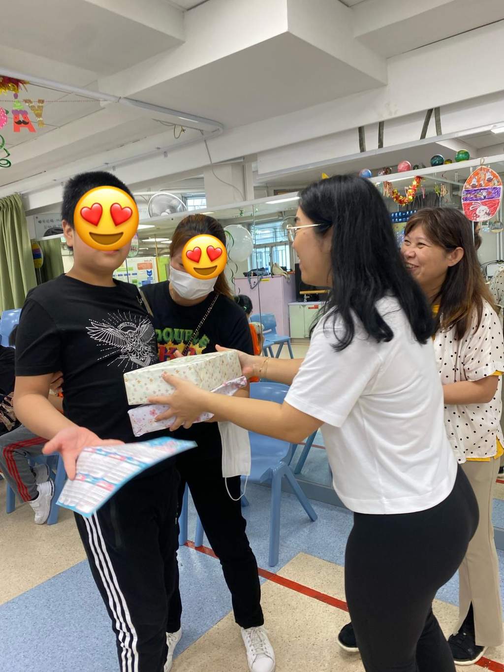An adult hands a wrapped item to a participant.