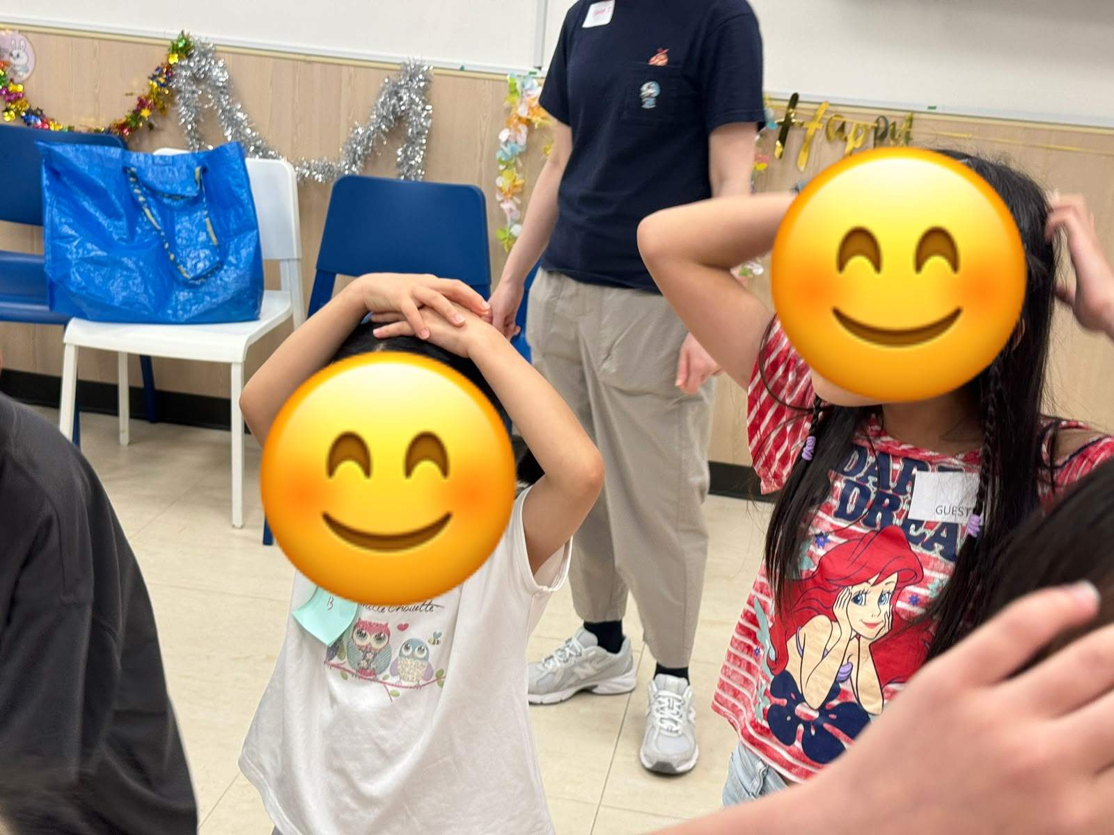 Two children crouch inside a red rope game boundary.