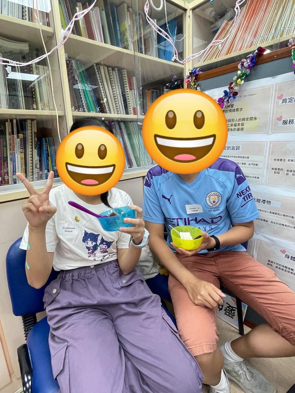 Two seated children pose together holding small gifts.