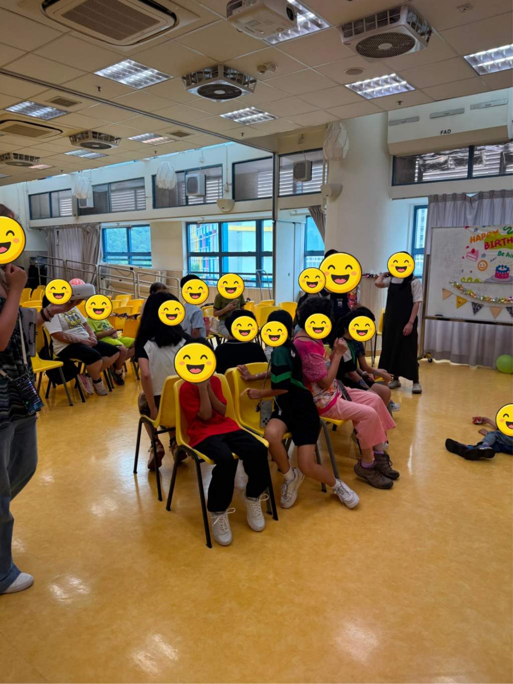 Participants sit on yellow chairs during a group activity.