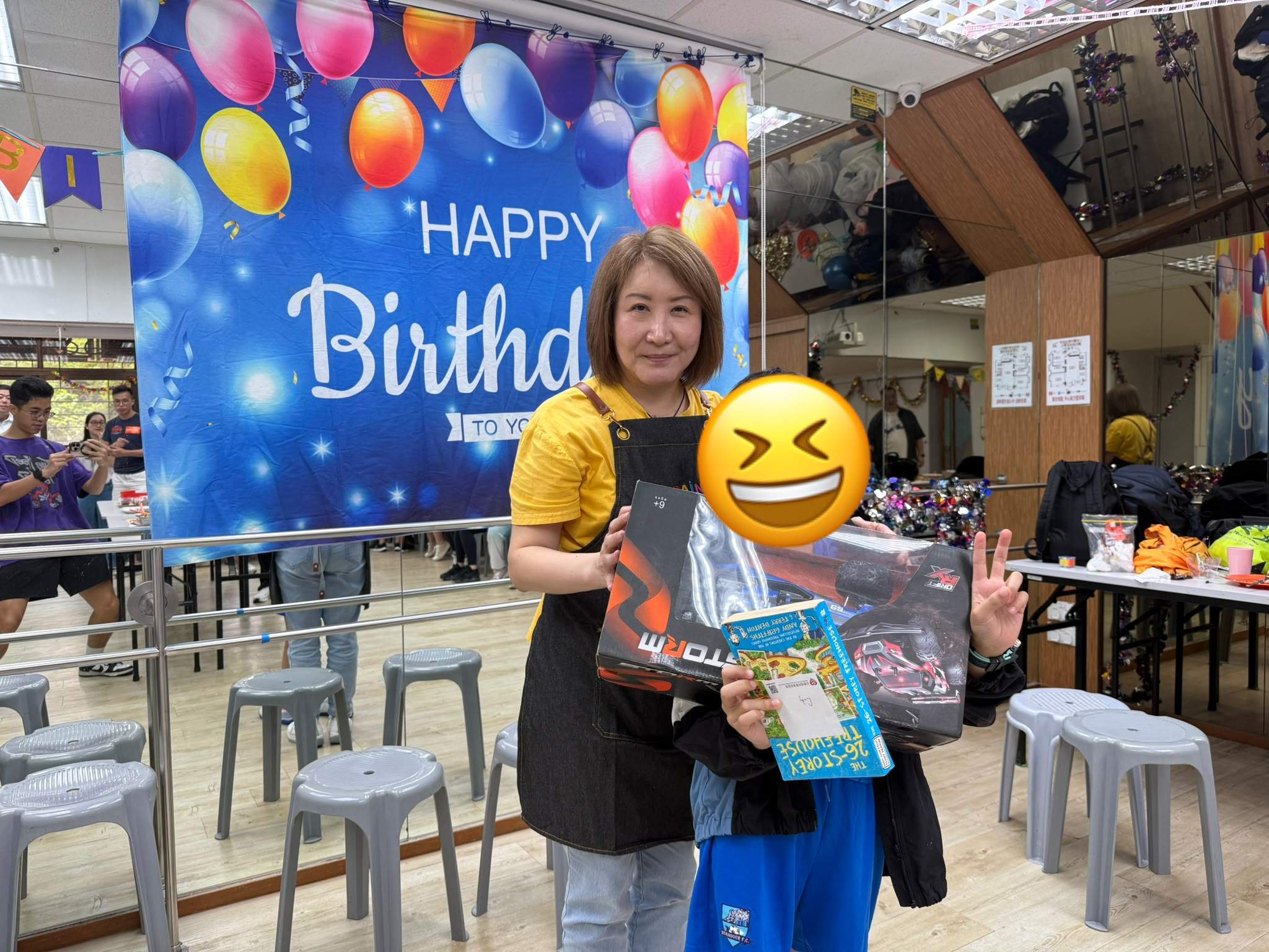 An adult and child hold boxed gifts together.
