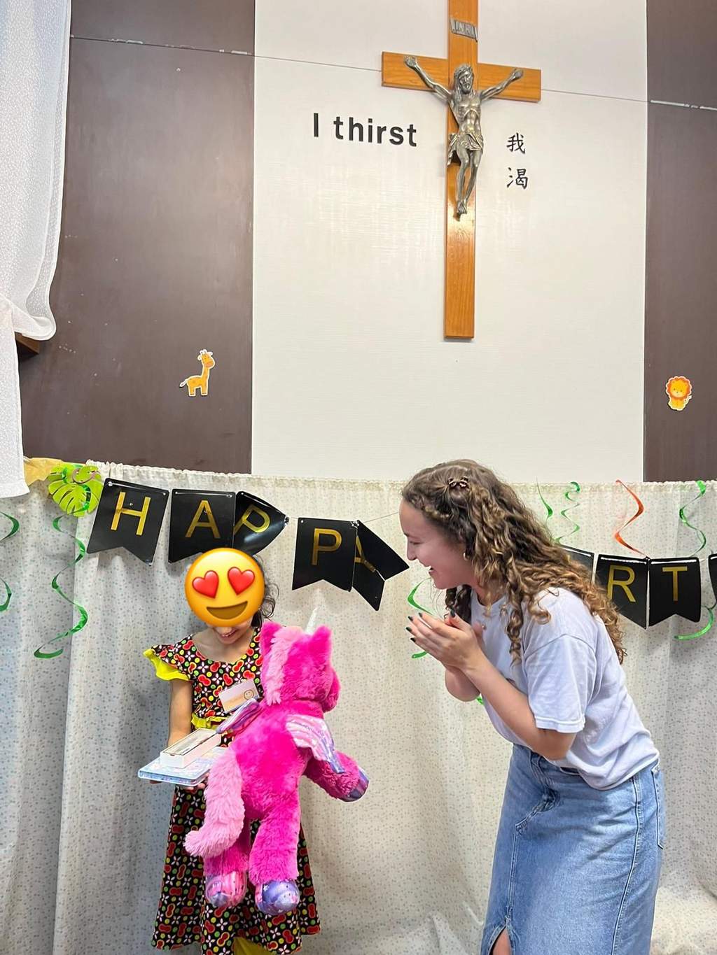 An adult helps a child strike a hanging party game.