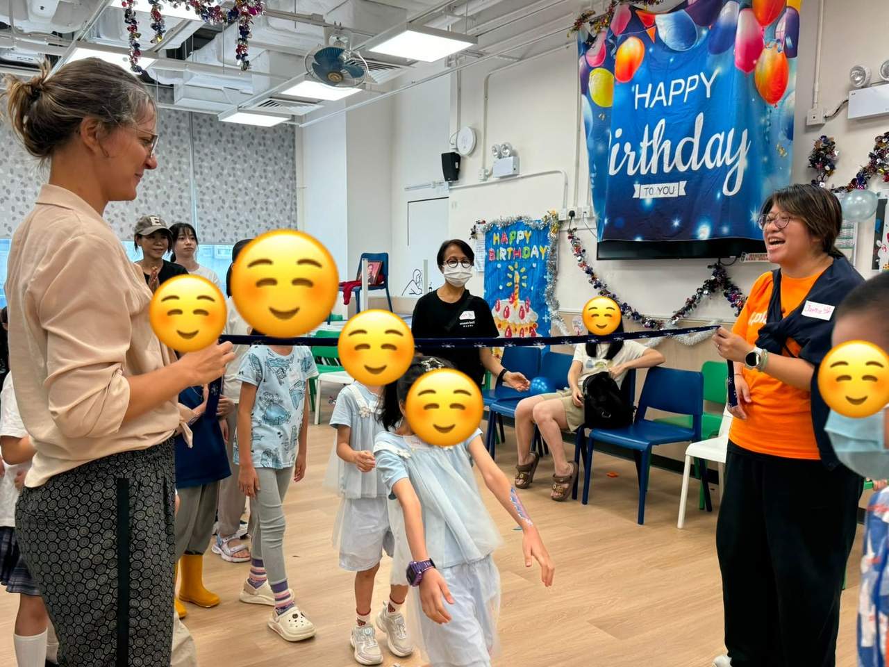 Children take turns moving beneath a limbo bar.