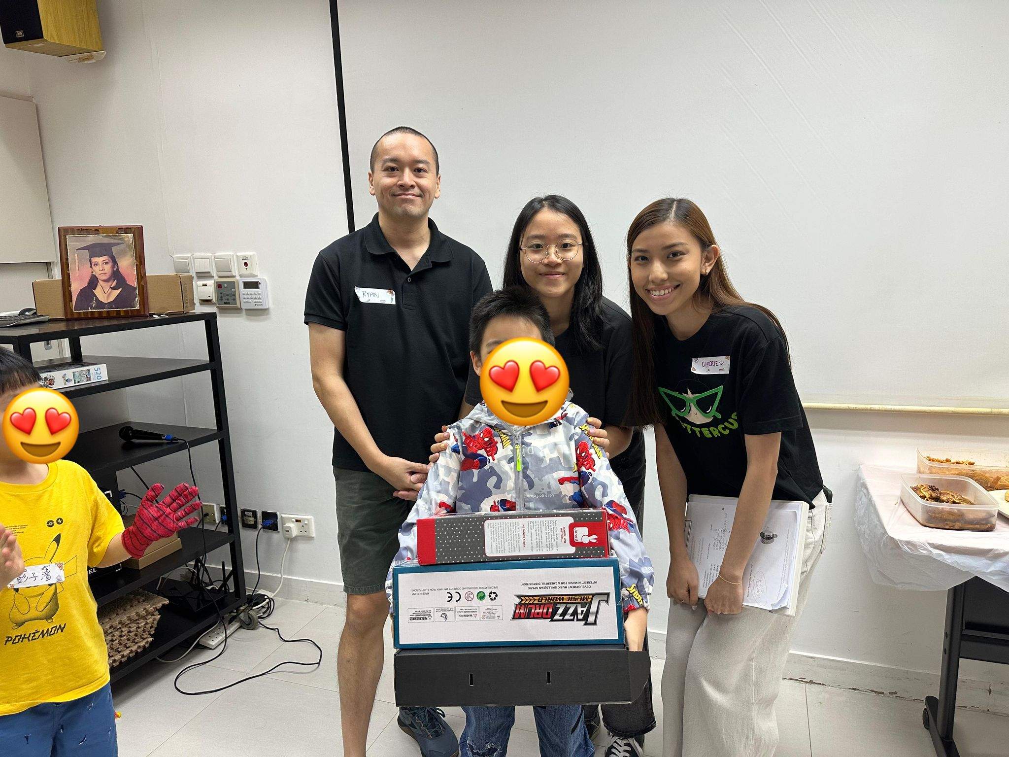 Three adults pose behind a child holding a large boxed gift.