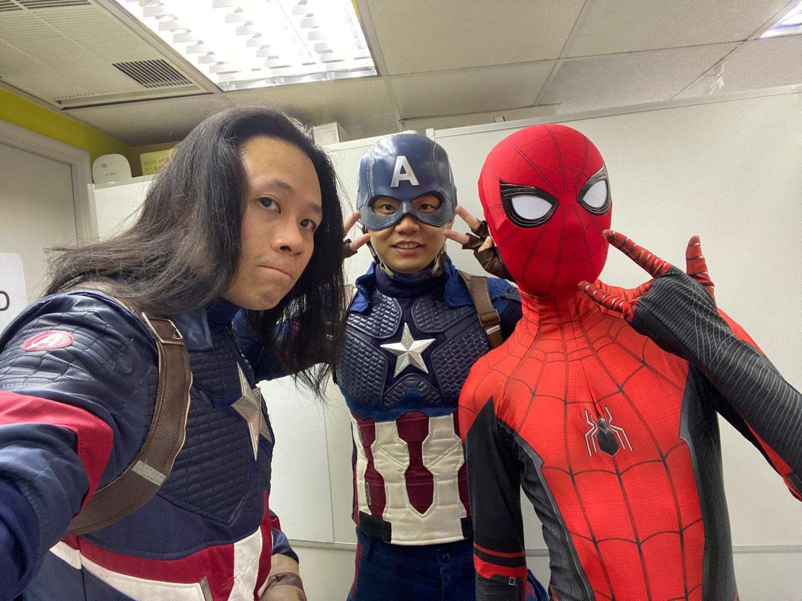 Three costumed performers take a close group selfie.