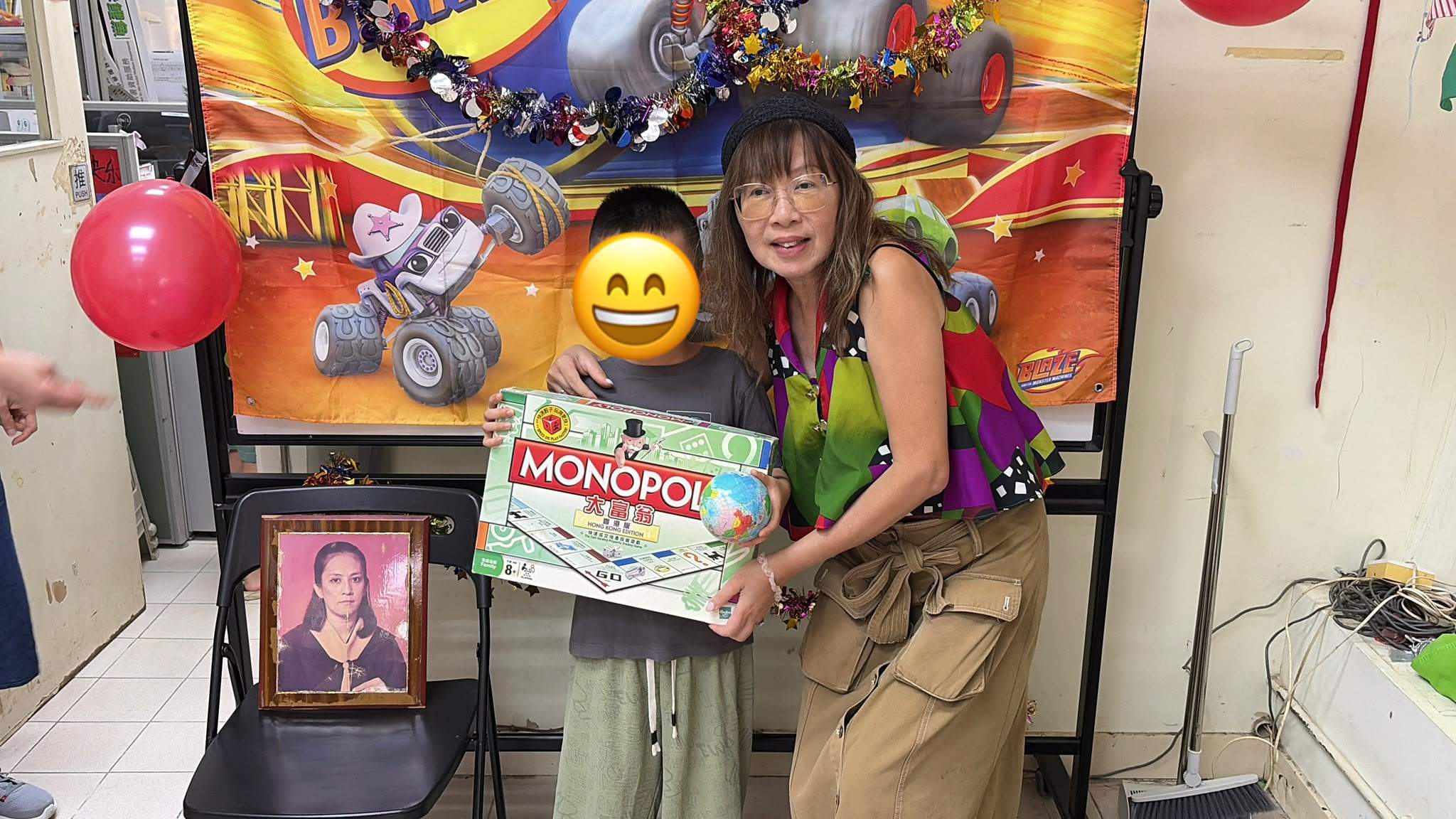 A child and volunteer hold a board-game gift together.