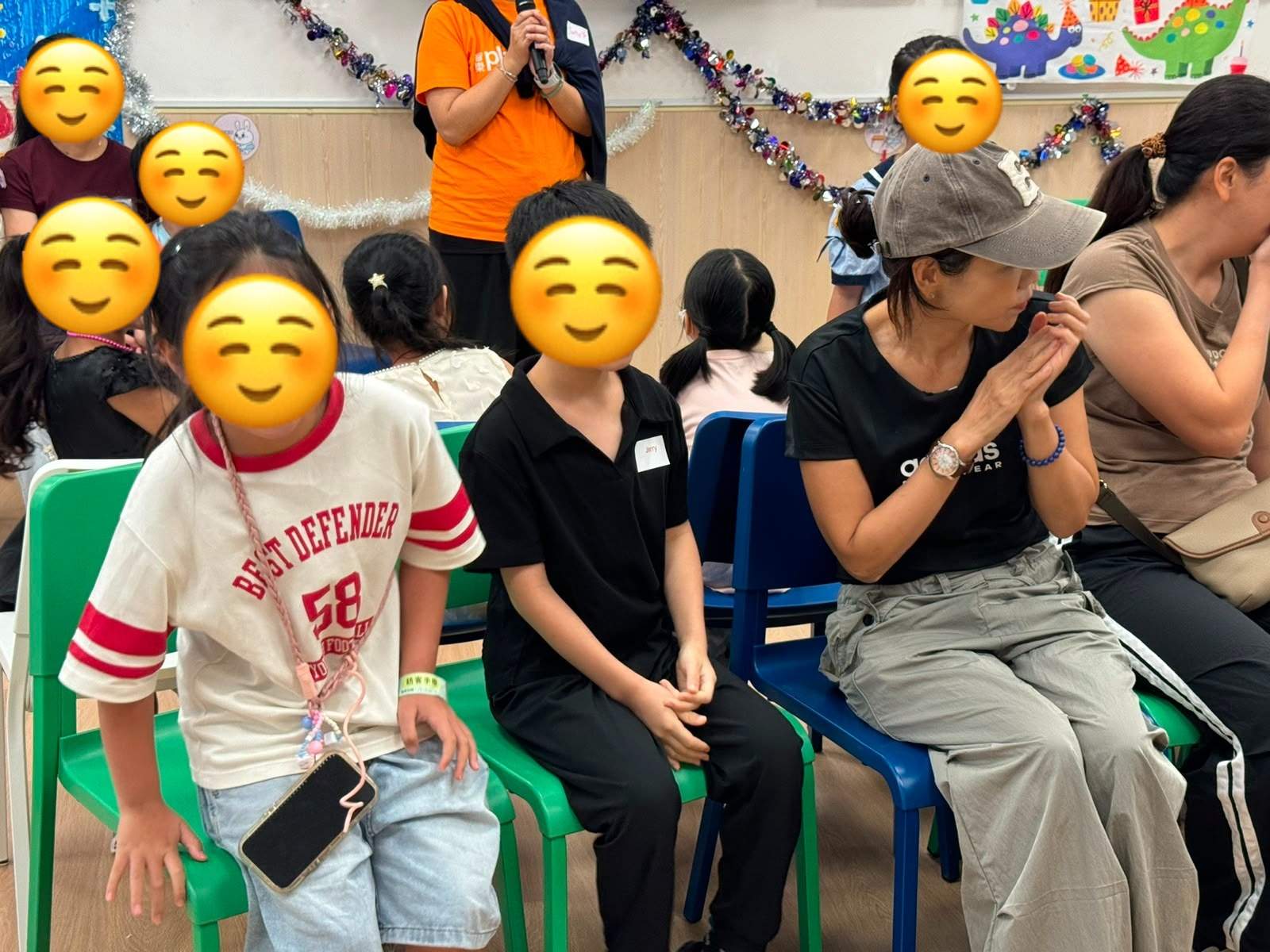 Children and adults sit together during a party game.