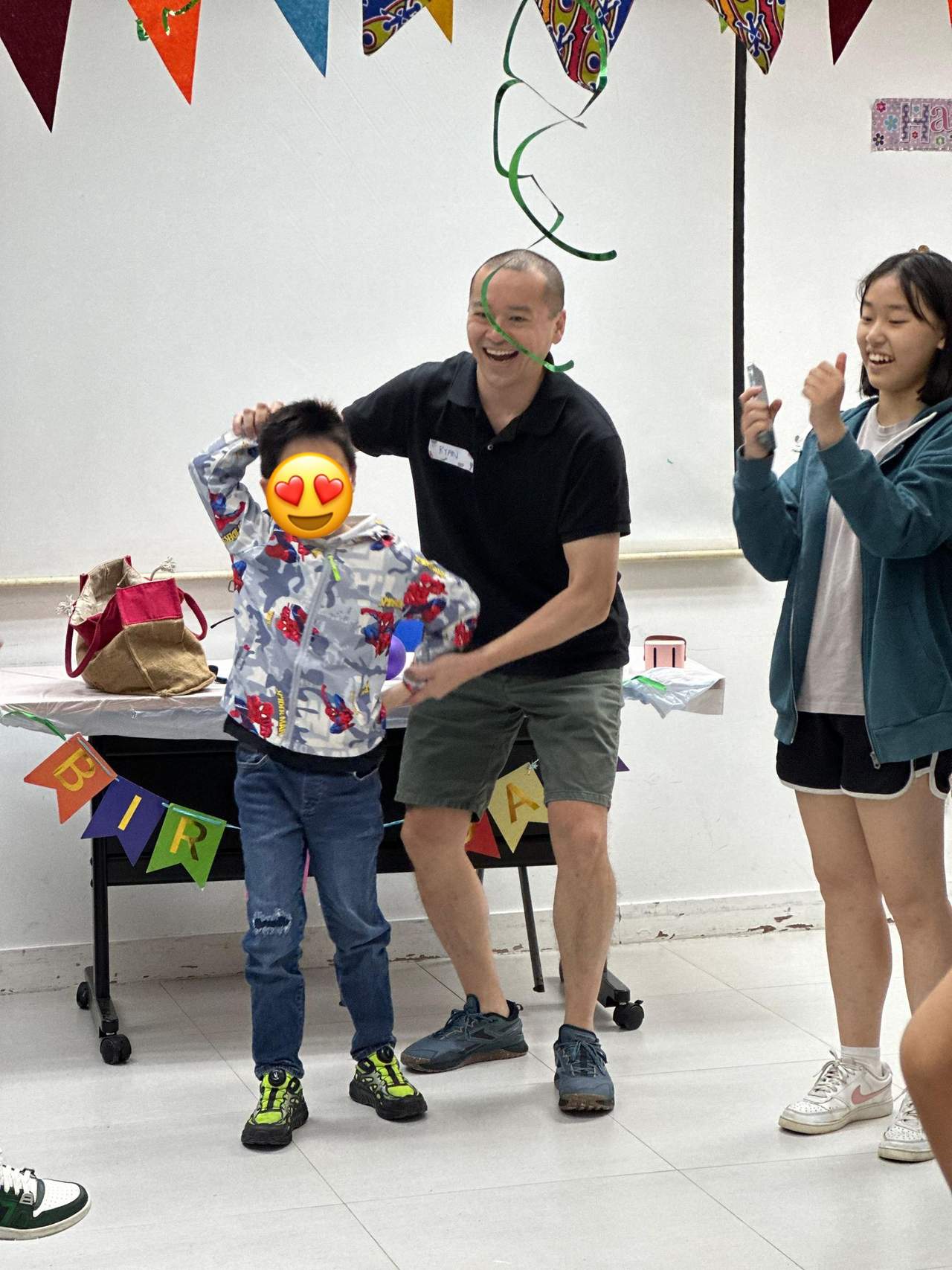 Two adults present a gift to a child.
