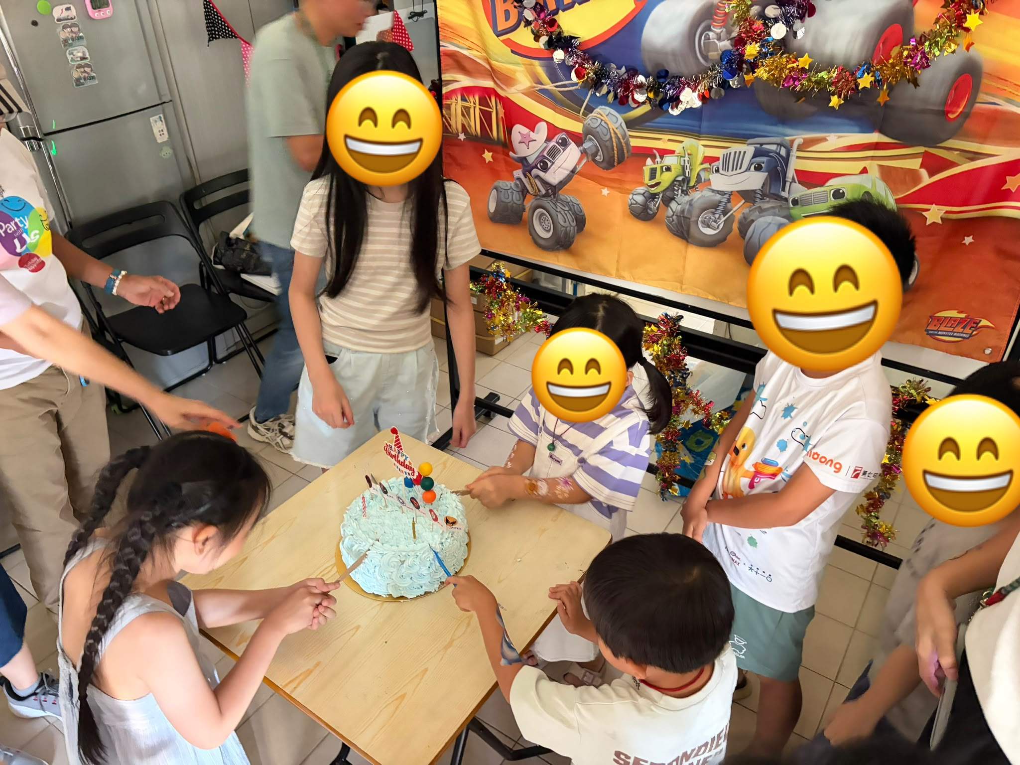 Children gather around a birthday cake during the celebration.