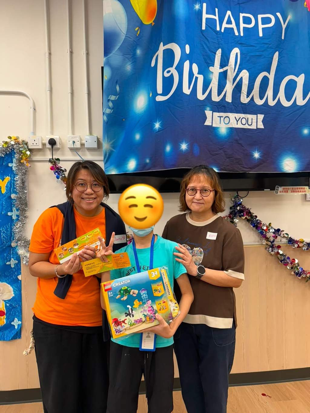 Two adults and a child display boxed birthday gifts.