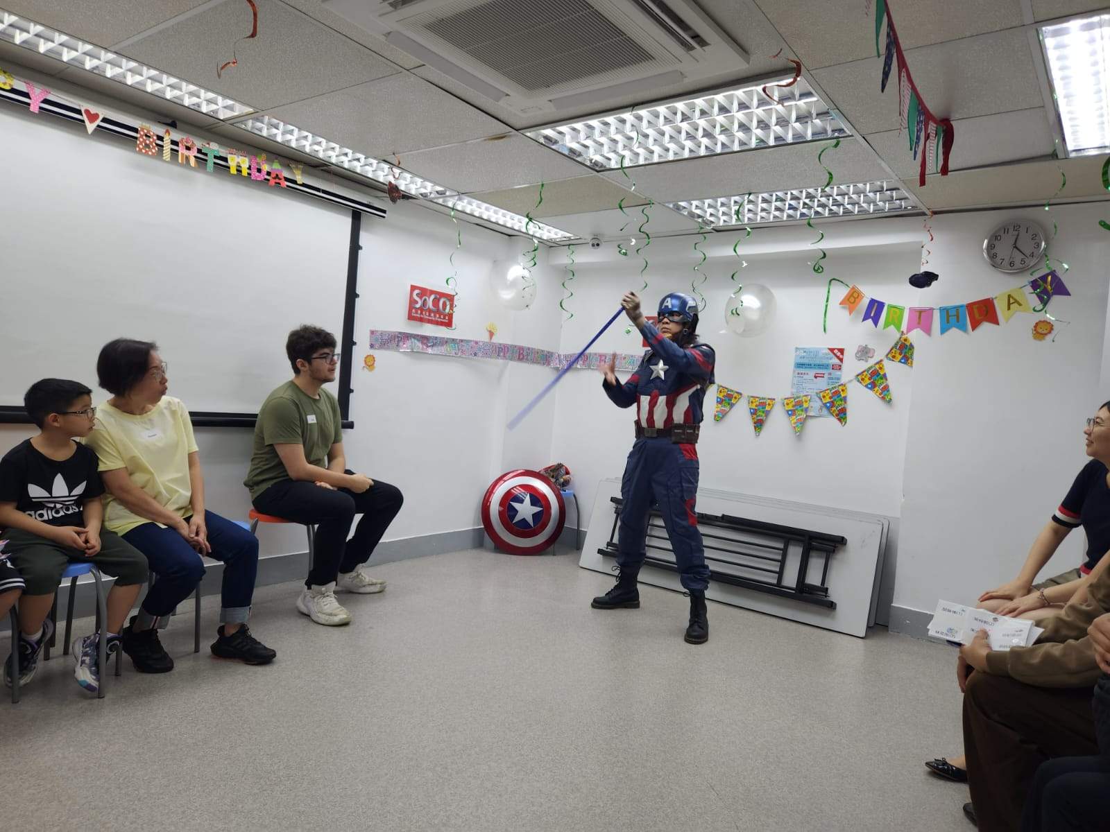 A costumed performer demonstrates an activity to seated children.