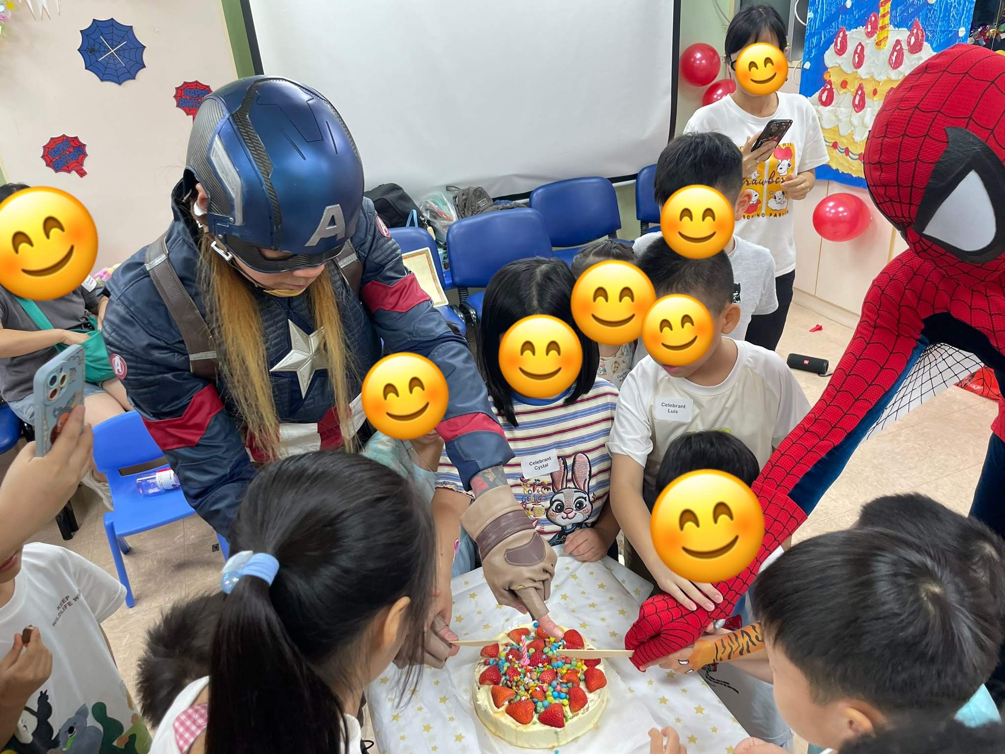 Children gather around a cake with two costumed adults.