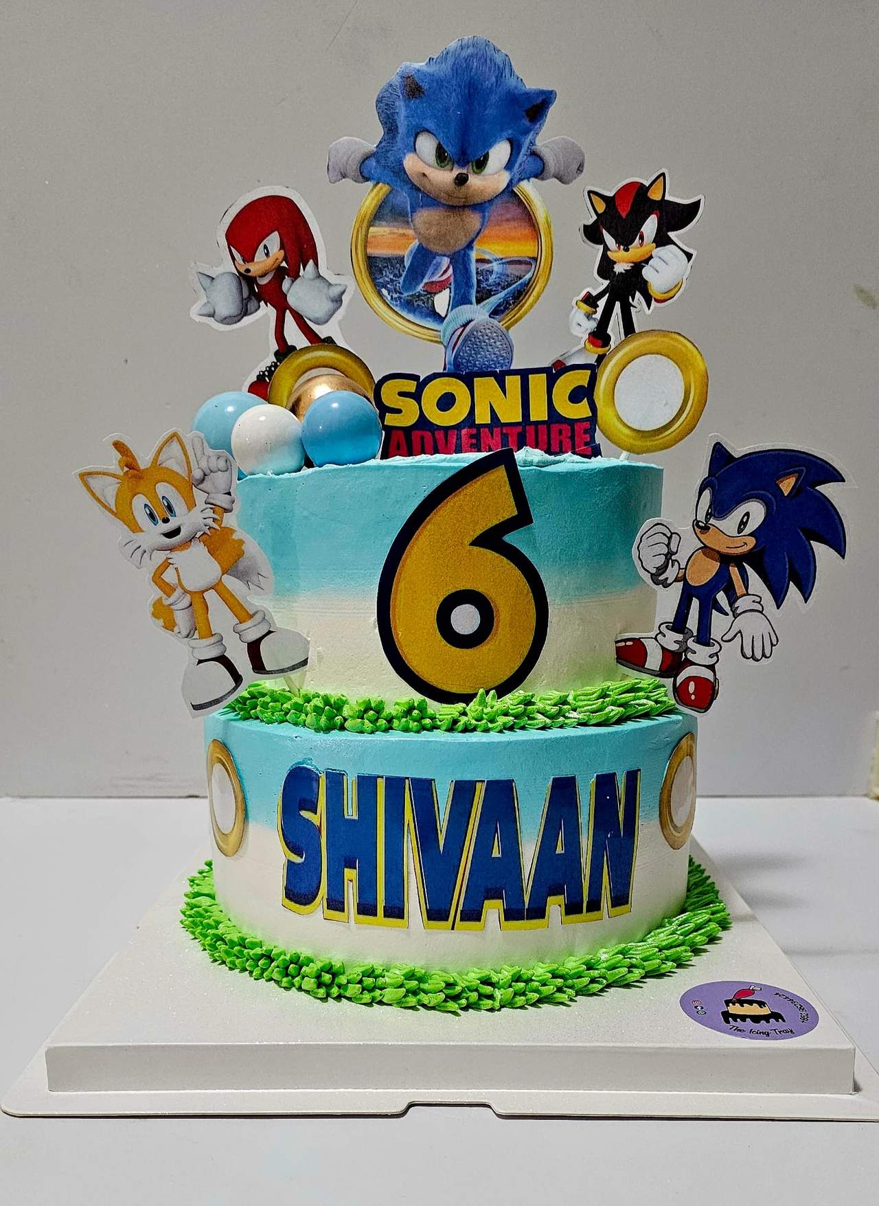Sonic the Hedgehog cake with blue frosting, character decorations and a large number six.