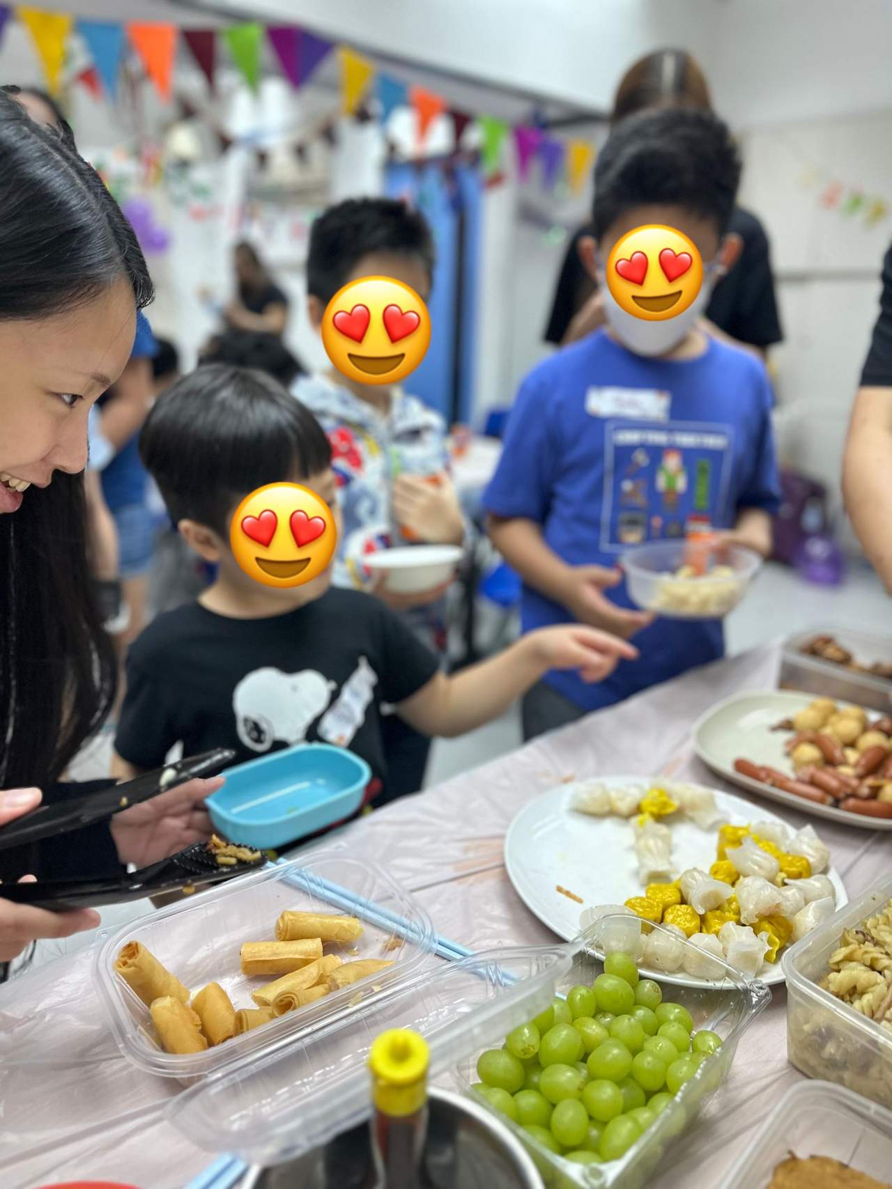 Children choose food from platters on a buffet table.