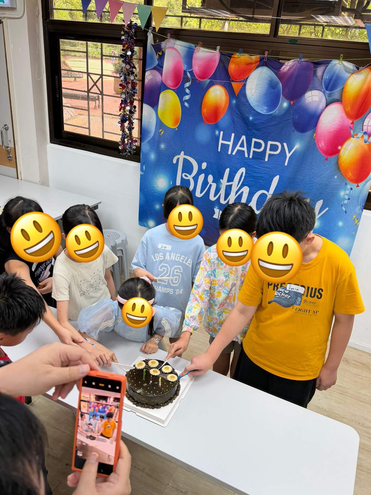 A group cuts a birthday cake together.
