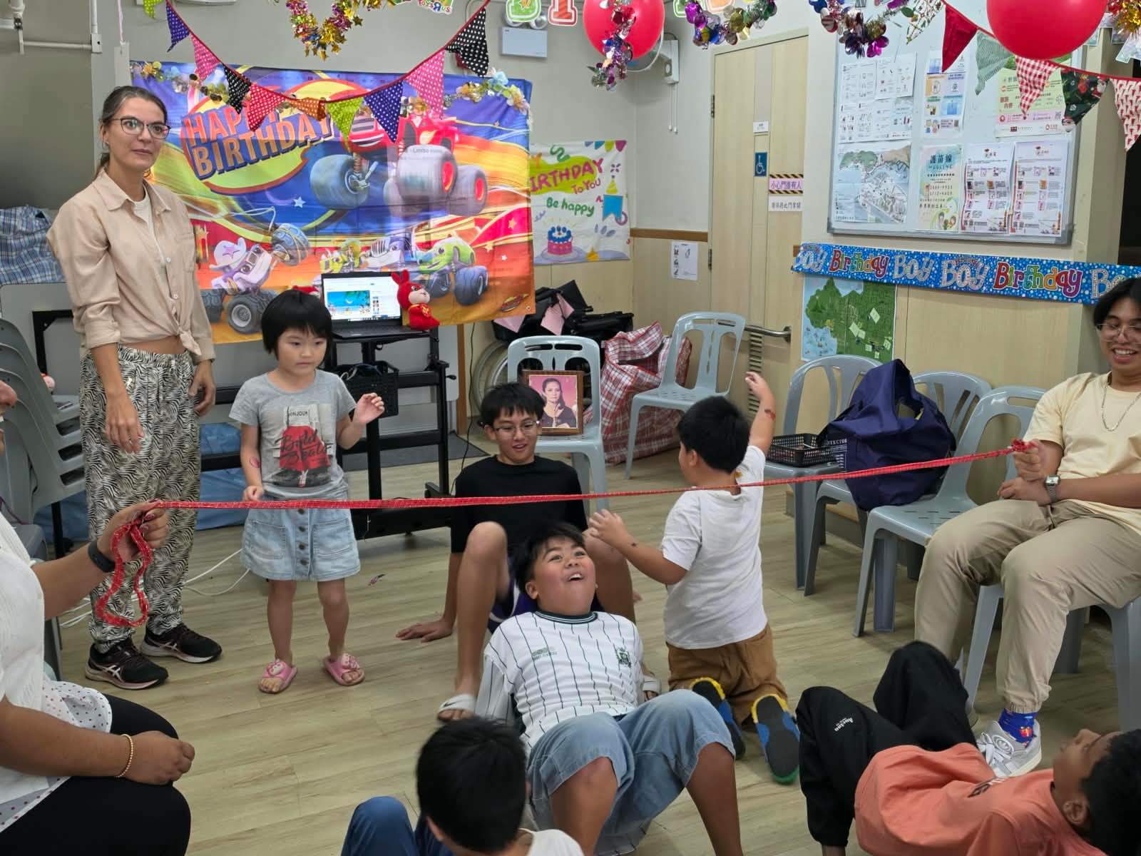 Children and volunteers play a lively limbo game.