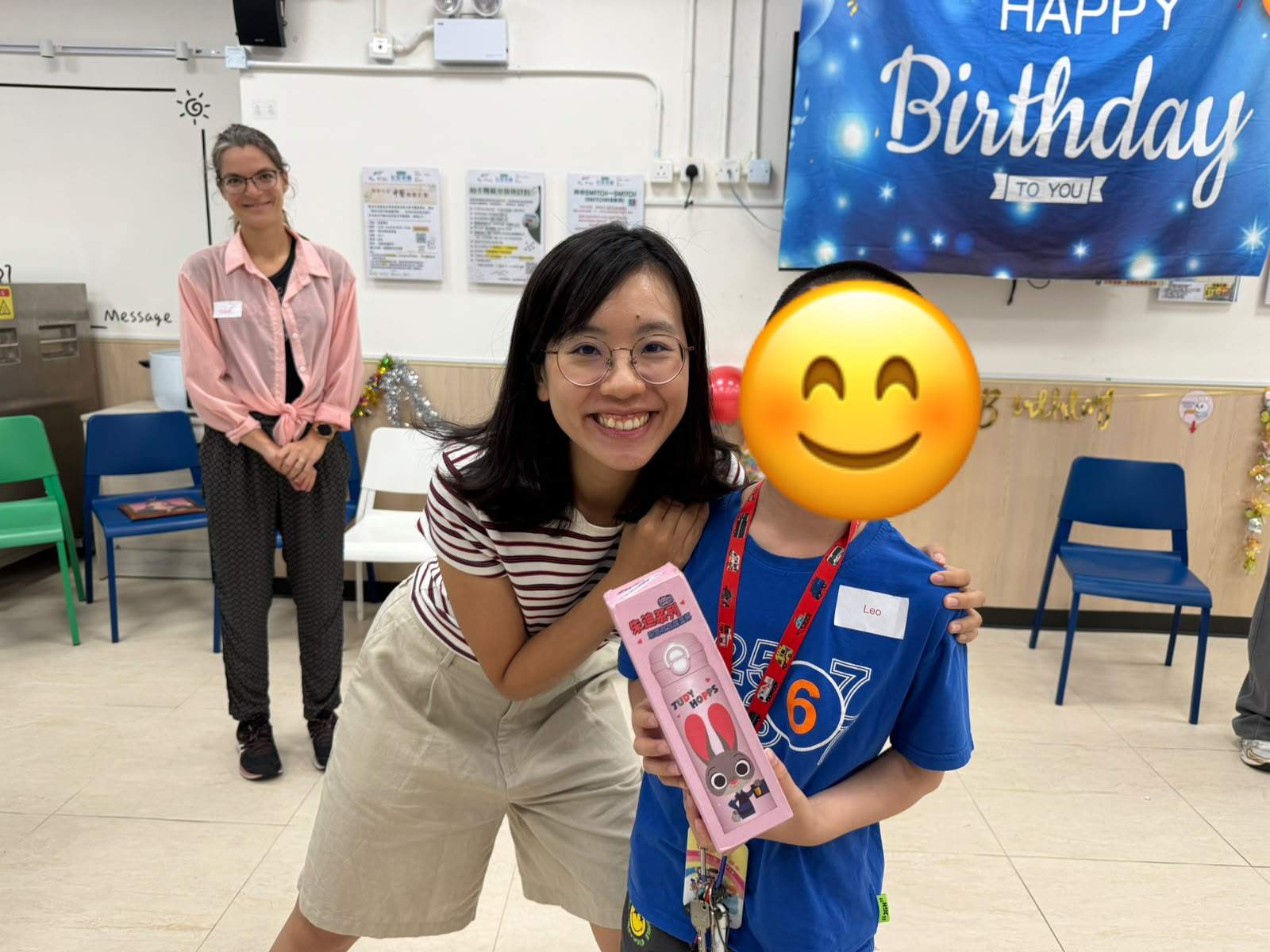 An adult crouches beside a child displaying a boxed gift.