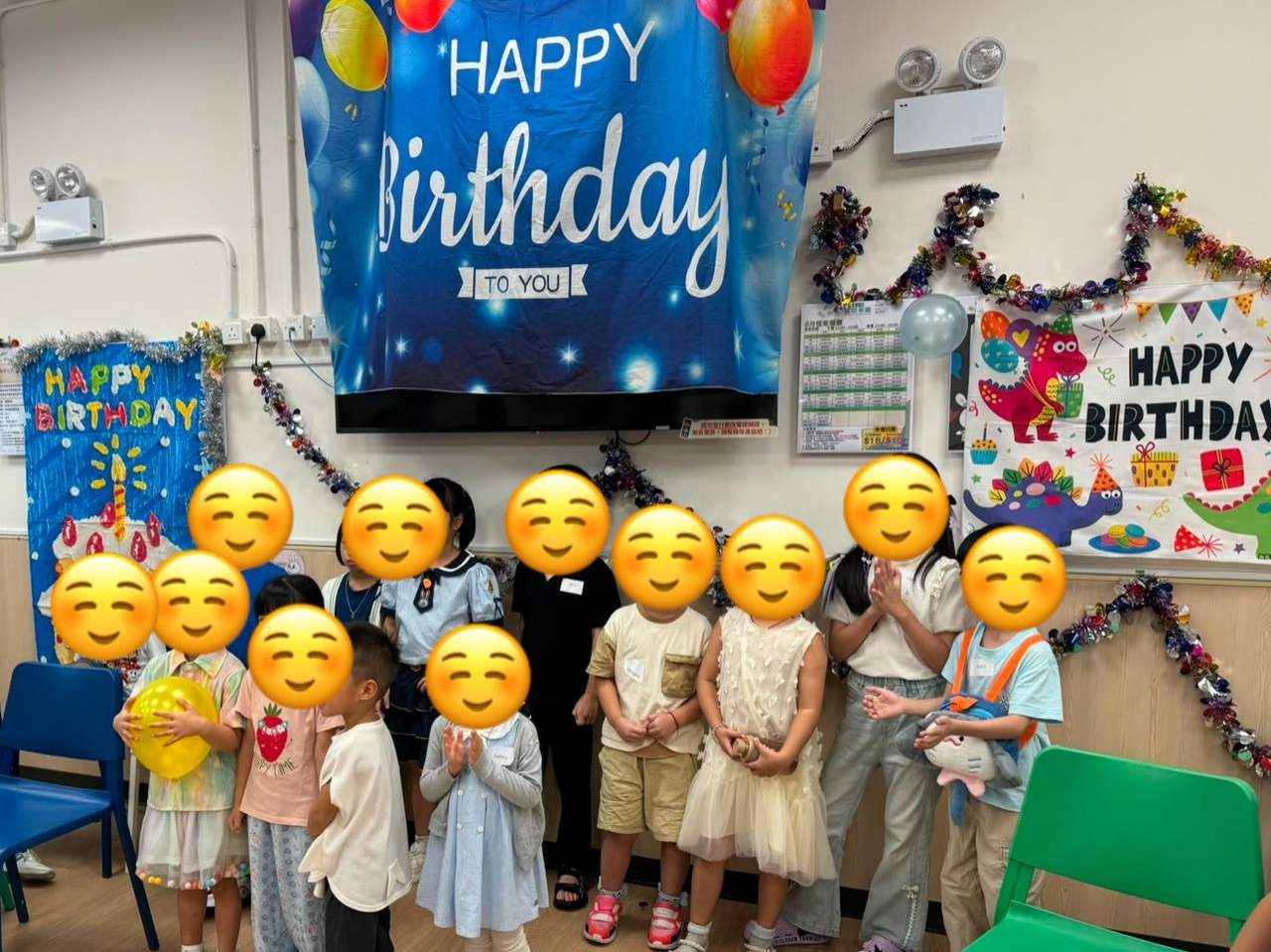 Children pose together beneath the birthday decorations.
