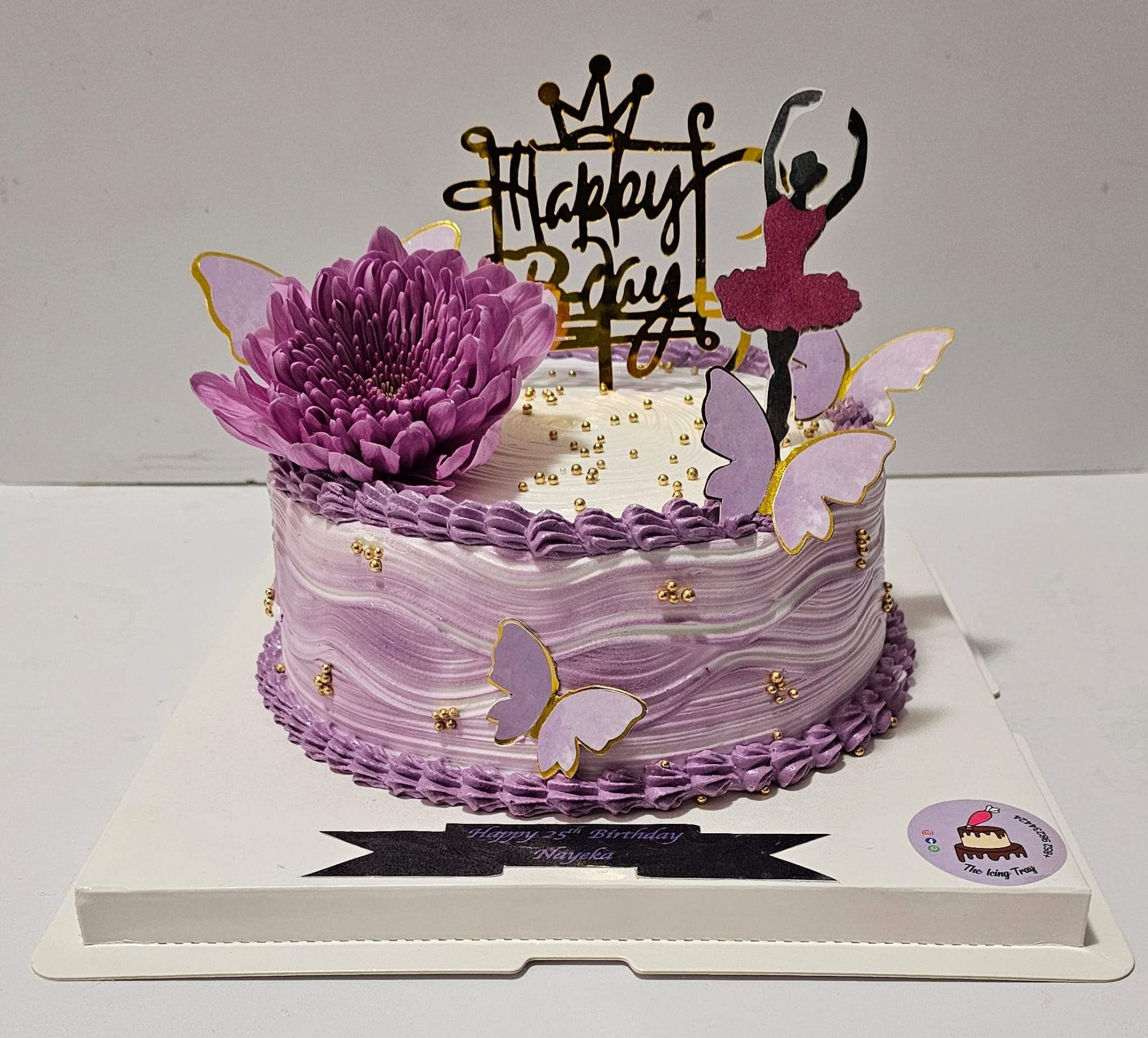 Purple floral birthday cake decorated with butterflies, a large flower and a ballerina silhouette topper.