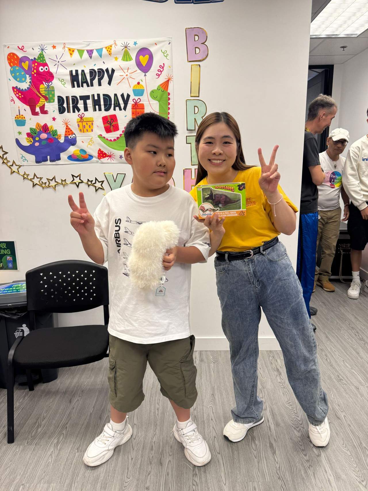 An adult and participant display a plush toy and gift.