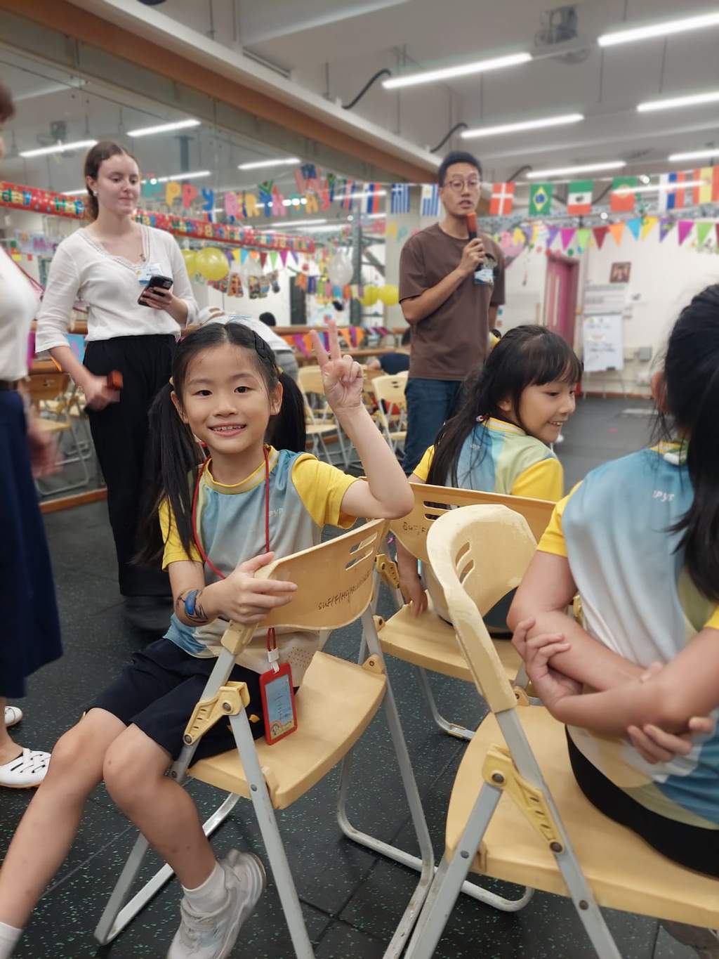 A seated child holds a paper craft during the gathering.
