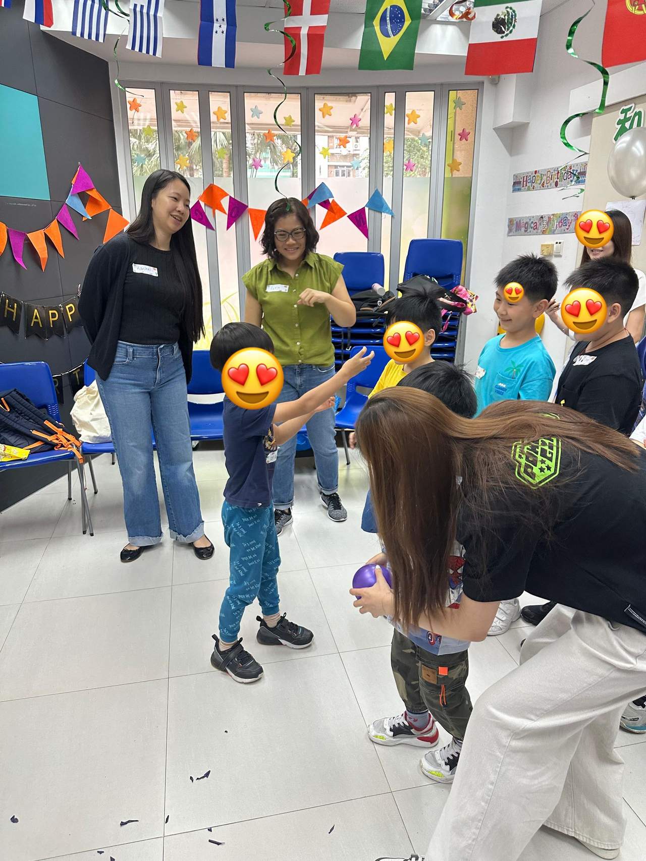 Adults help children during a standing group game.