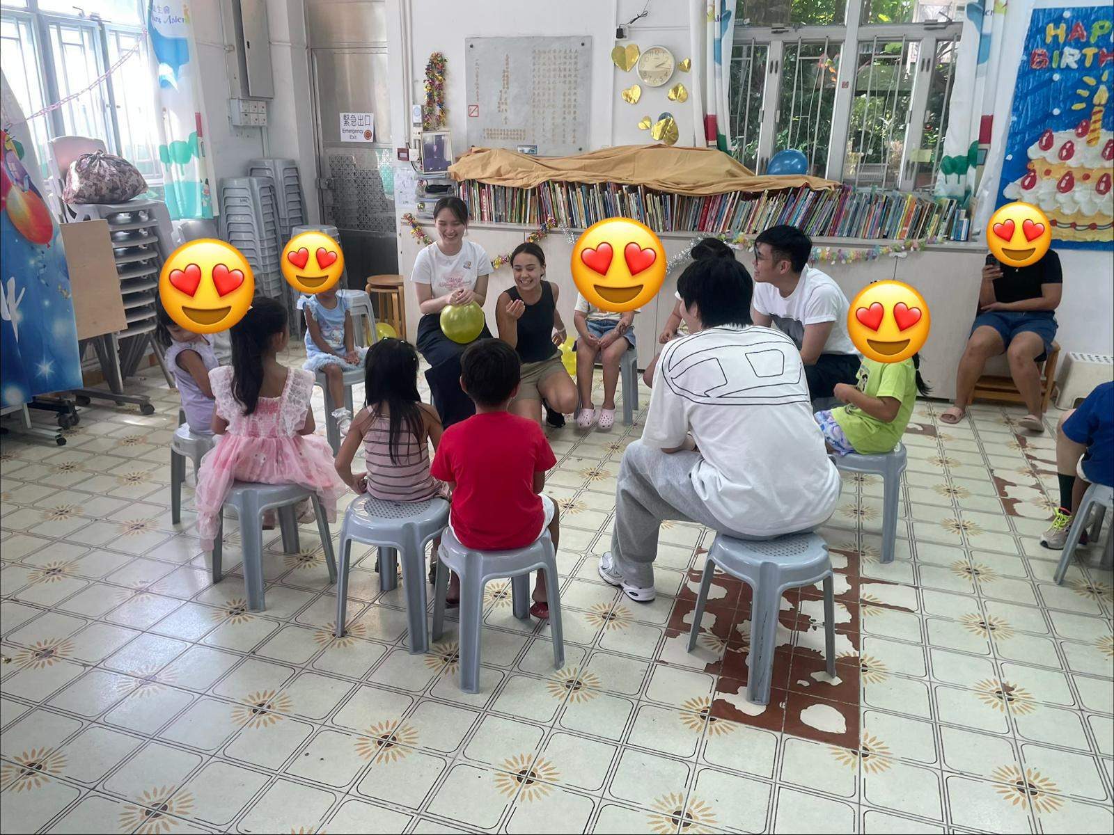 Children and adults sit in a circle during a group activity.