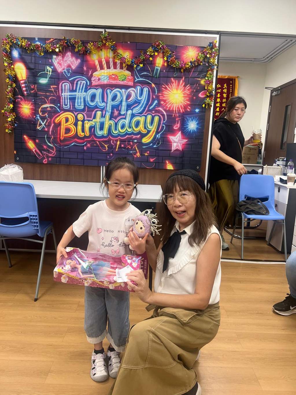 A child and seated adult display a wrapped gift.