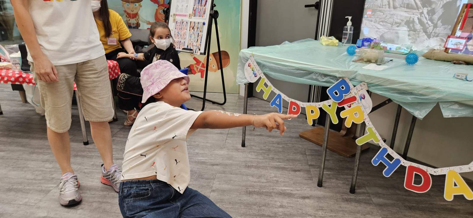 A child reaches towards bunting stretched across a table.
