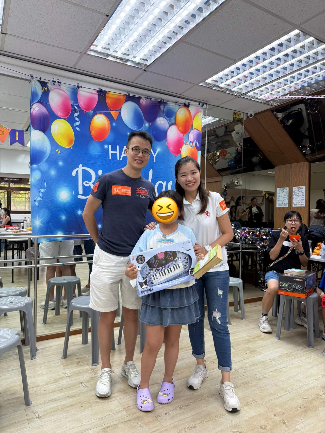 Two adults stand behind two children displaying gifts.