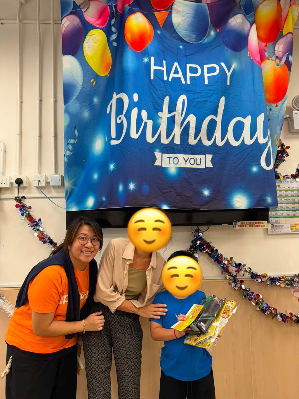 Two adults and a child pose with birthday gifts.