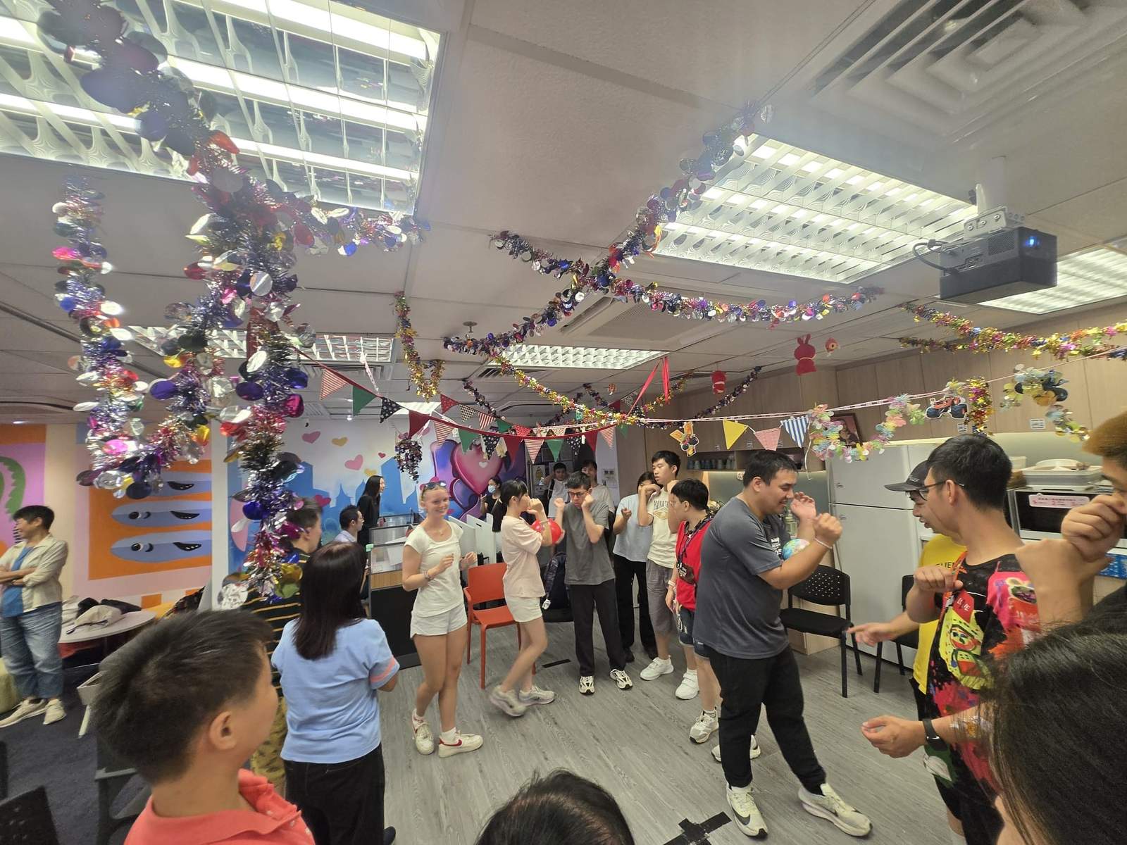 The group follows a lively activity beneath hanging decorations.