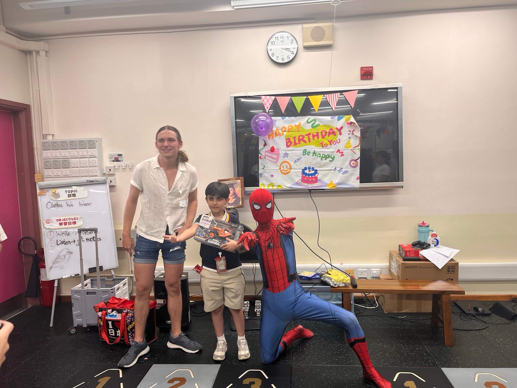 Adults and a costumed performer pose with a child and gift.