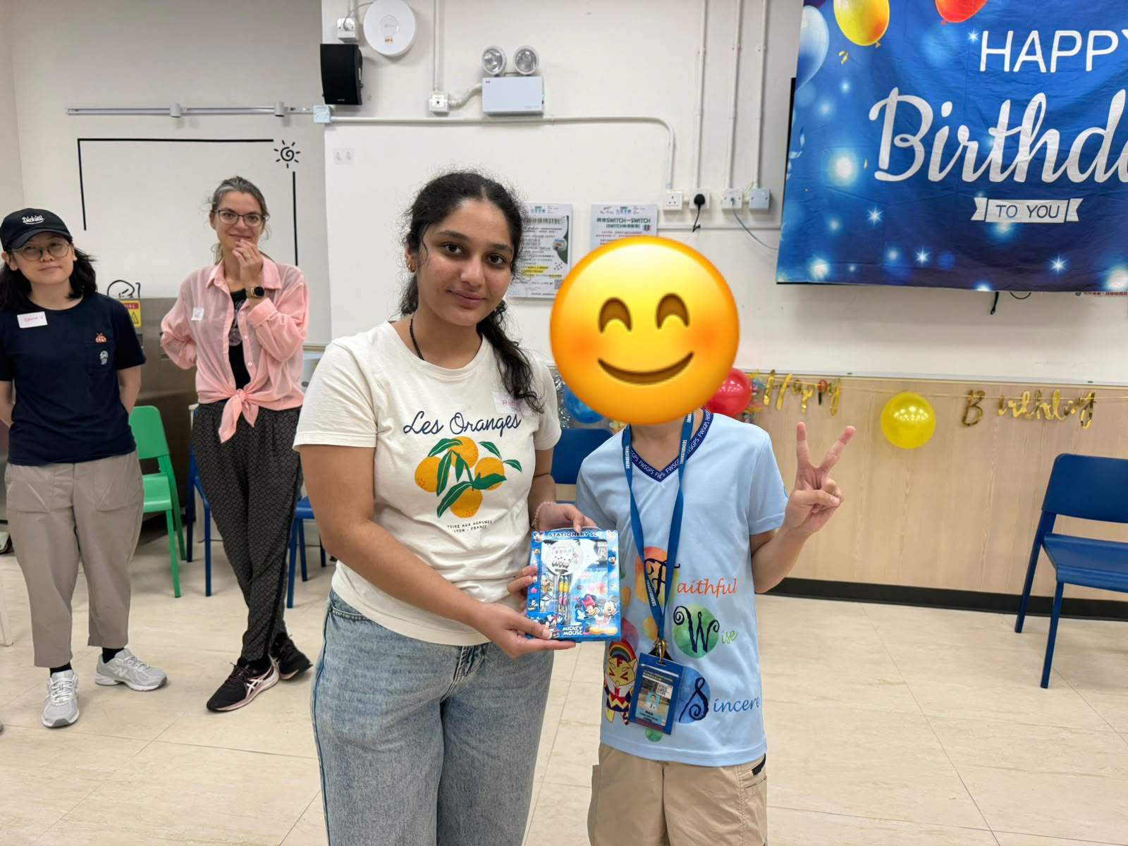 An adult and child hold a small boxed gift together.