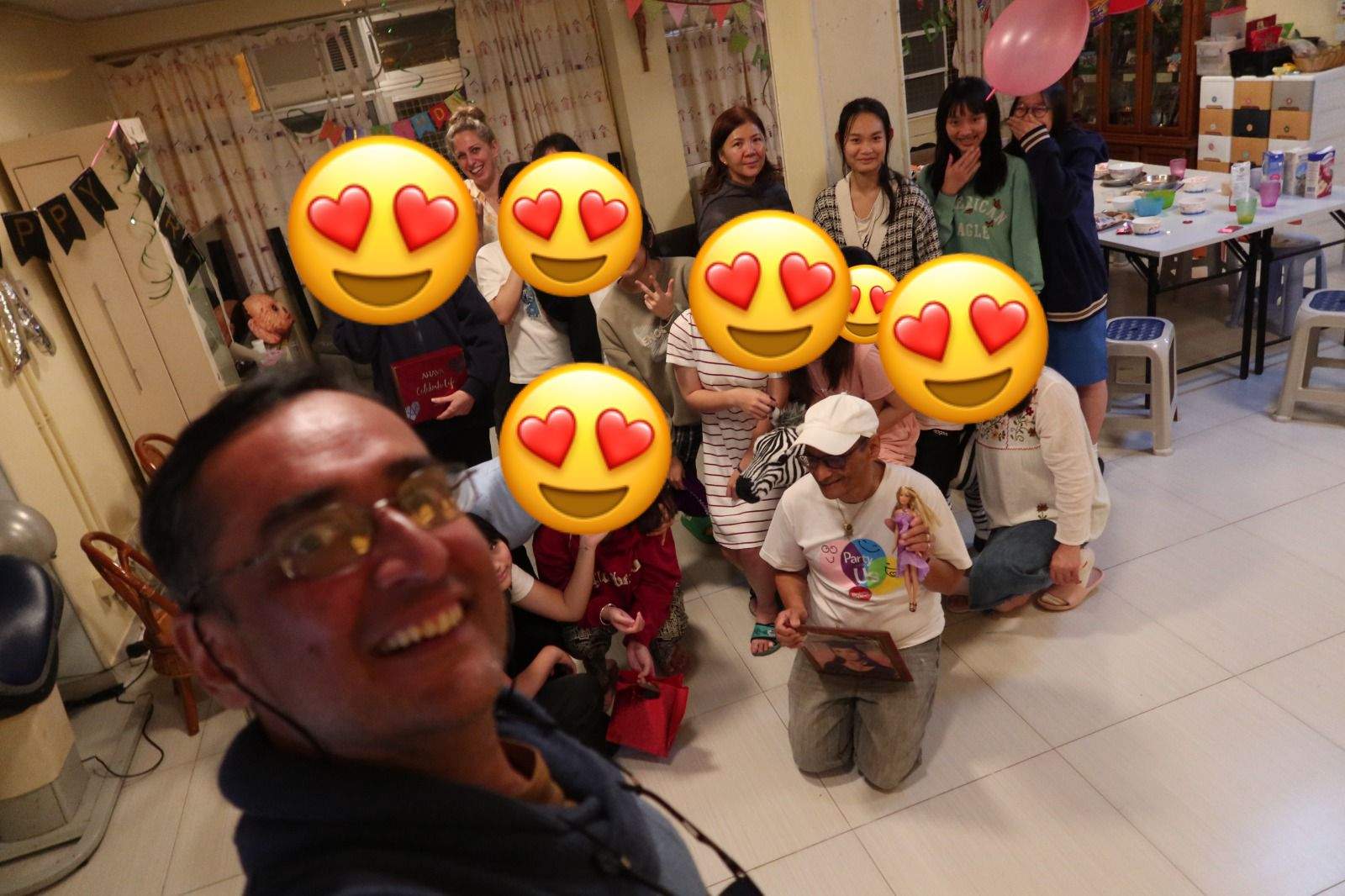 An adult takes a group selfie in the decorated room.