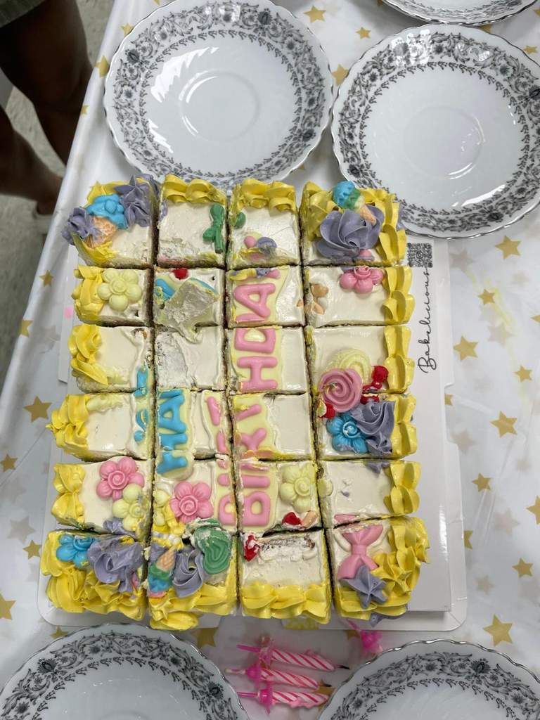 A rectangular frosted cake is divided into colourful sections.