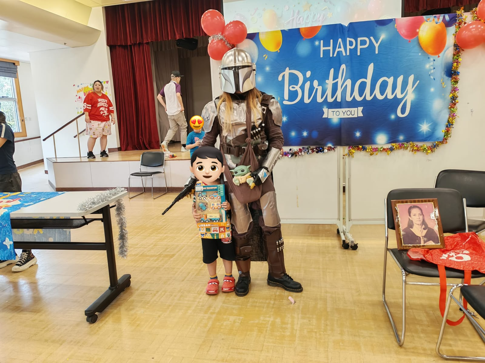 A child displays a gift beside an armored character.