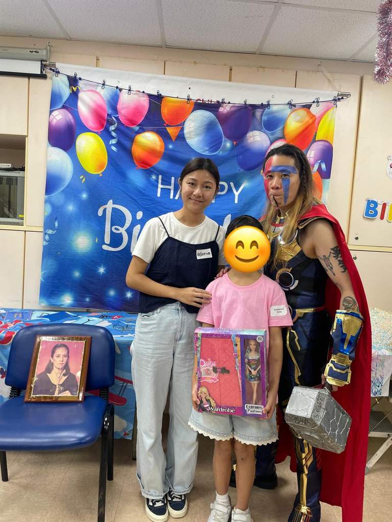 Two adults pose with a child holding a boxed gift.