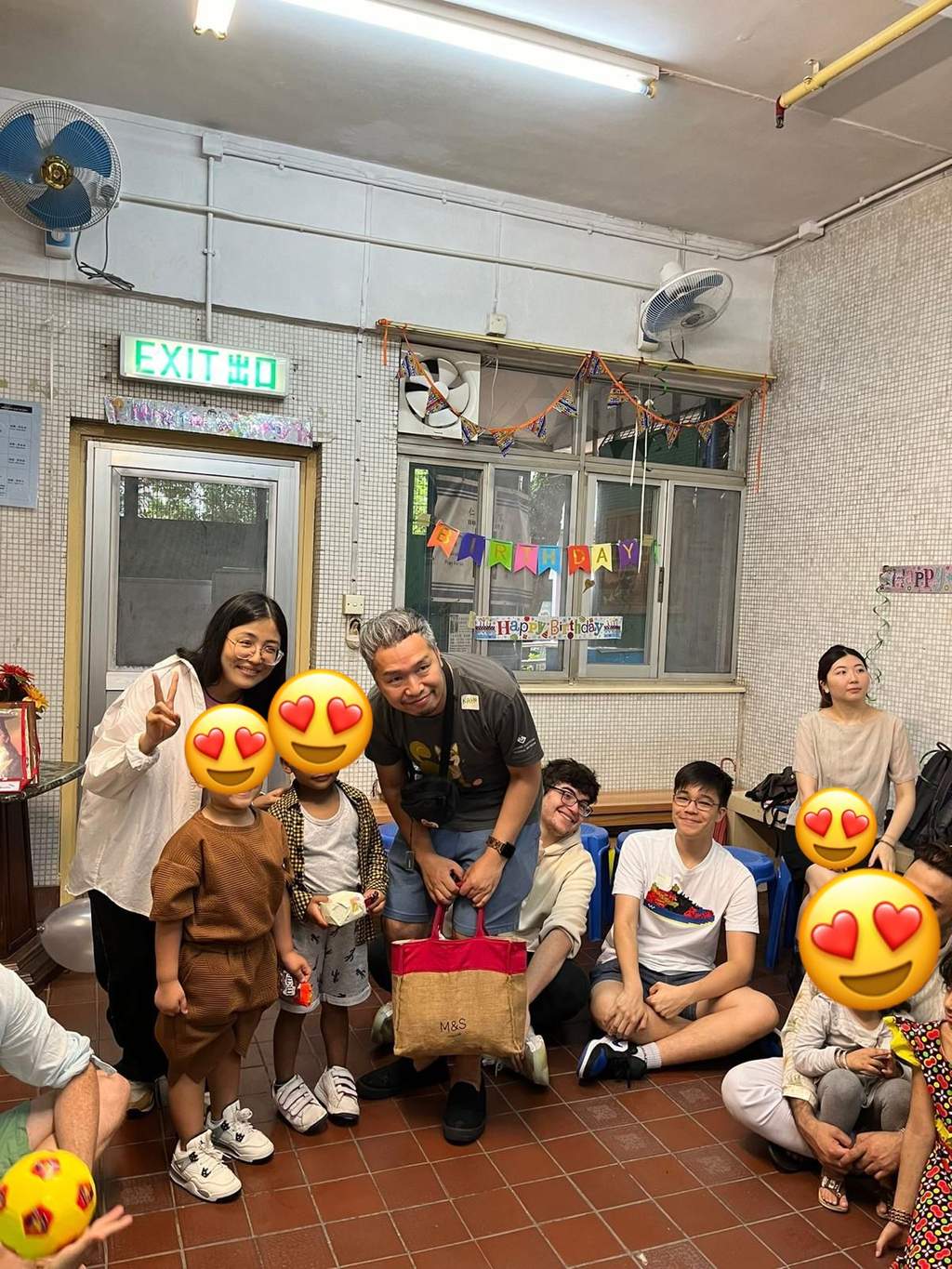 Adults and children pose together in the decorated room.
