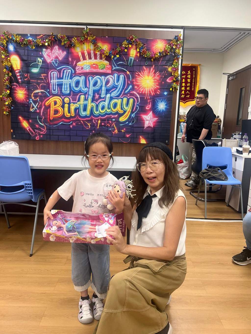 A child and seated adult hold a wrapped gift together.