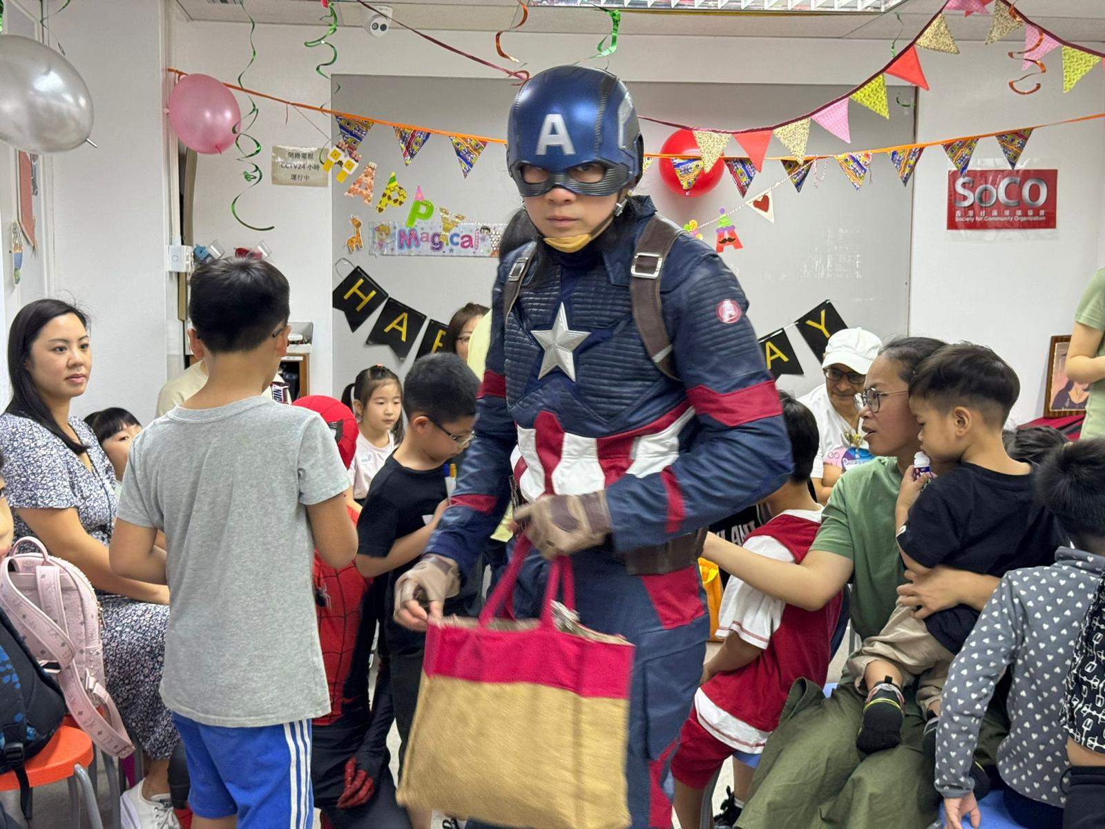 A costumed performer carries gift bags through the crowded room.