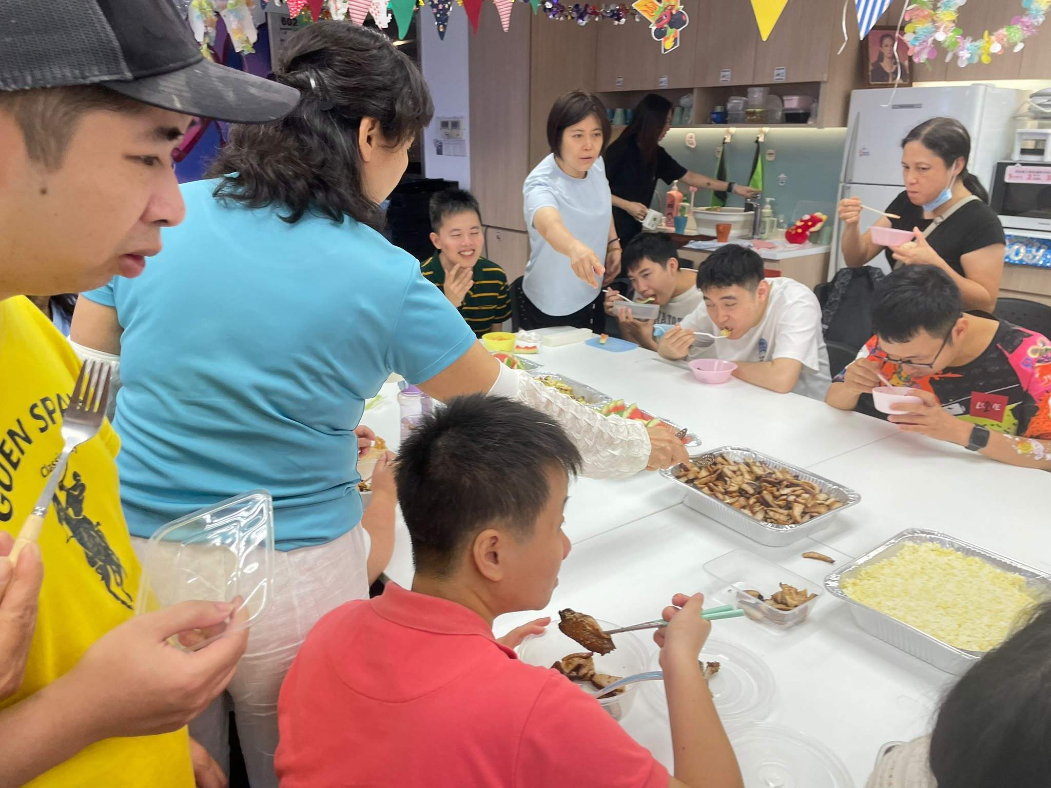A volunteer helps a participant during a hands-on table activity.